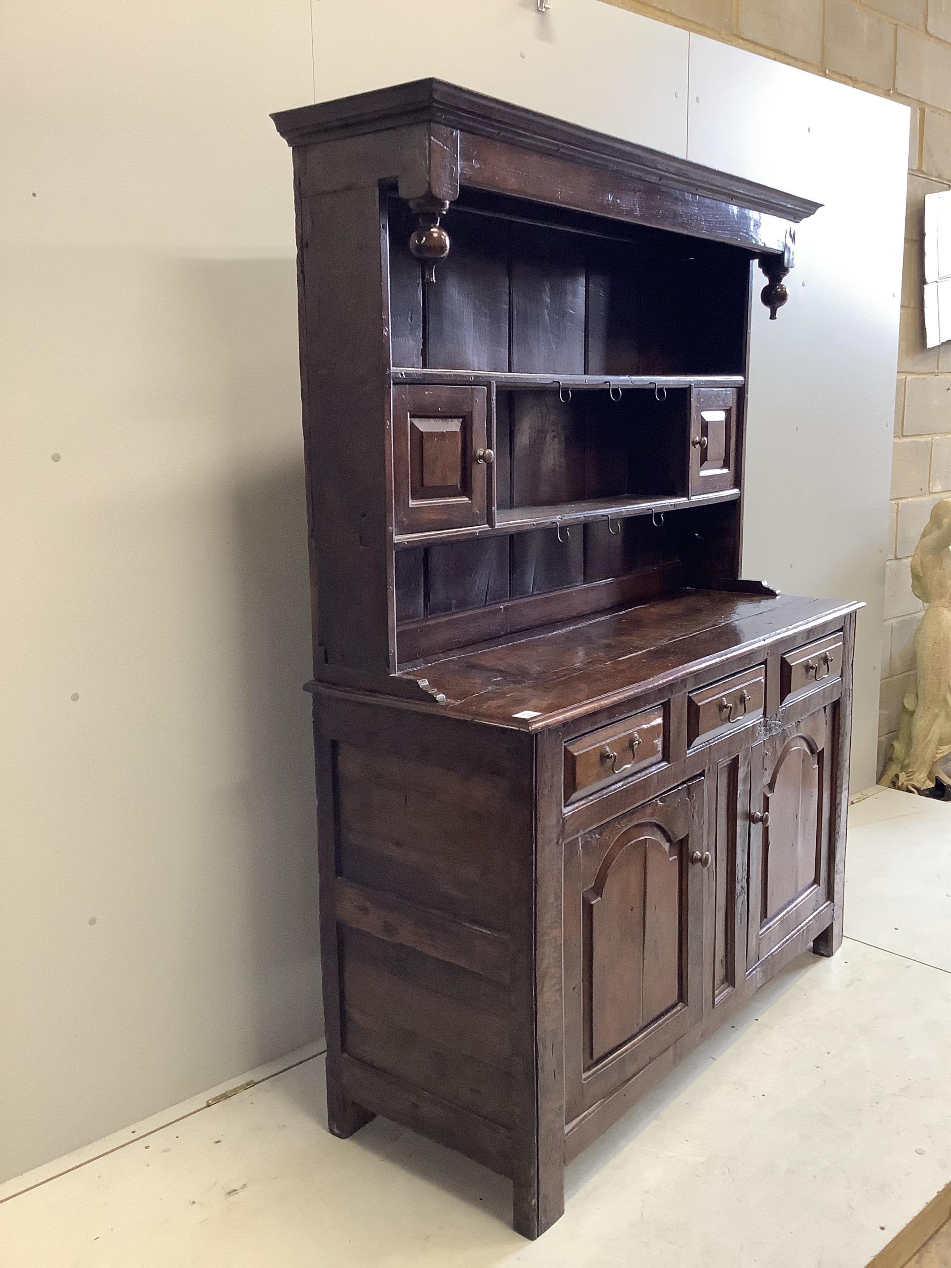 An early 18th century oak dresser, width 142cm, depth 52cm, height 188cm. Condition - fair